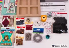 Detailausschnitt mit Spellbinders-Chipboard-Bogen, Holz-Schattenkasten, Glitter und schwarzen Filz-Punchouts.